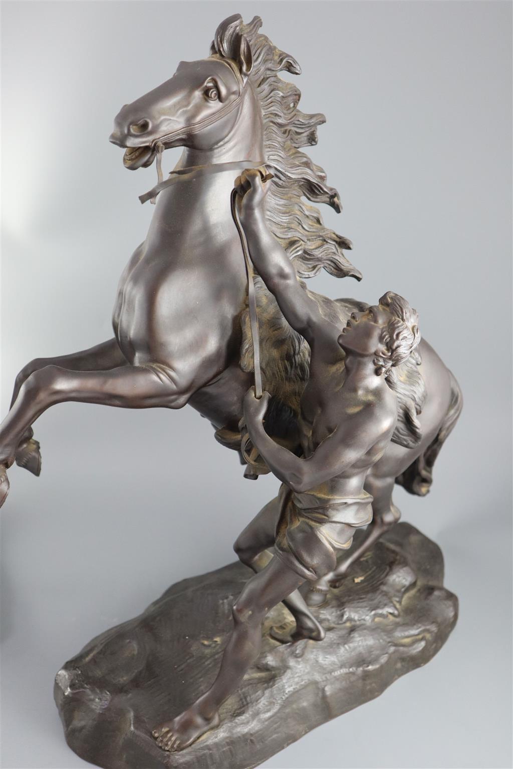 After Guillaume Coustou the Elder (French 1677-1746). A pair of bronze Chevaux de Marly, height 19in.